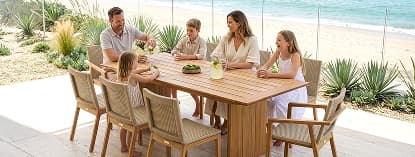 Family enjoying lunch around wooden table.