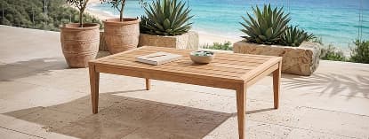 Wooden coffee table on sunny patio.