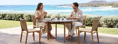 Couple sitting at round outdoor table.