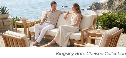Couple sitting on cushioned teak sofa. Image Text: Kingsley Bate Chelsea Collection