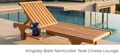 Teak chaise lounge with an attached side tray, pitcher and glass beside an infinity pool.