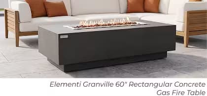 Dark gray Elementi Granville rectangular gas fire table with lava rock and flames on a modern patio.