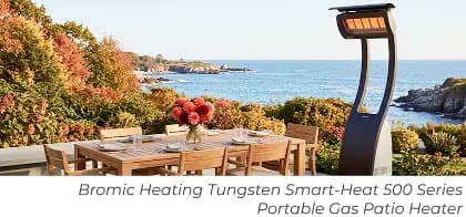 Portable freestanding patio heater beside a teak dining set overlooking the ocean.