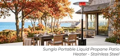 Portable propane patio heater beside a dining set on a coastal patio surrounded by autumn foliage.