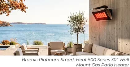 Wall-mounted patio heater above a modern outdoor lounge with cushioned seating and an ocean view.