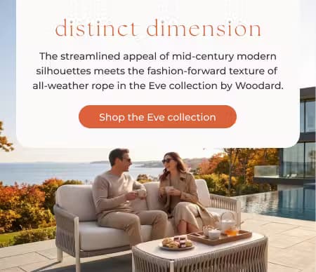 Couple enjoying coffee on a cushioned outdoor loveseat from the Woodard Eve collection beside a pool with an autumn coastal view.