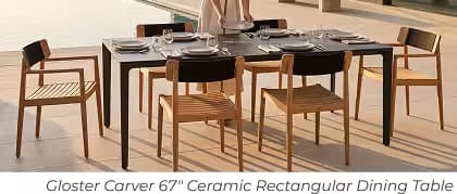 Marble rectangular outdoor dining table with teak chairs set for a meal beside a pool.